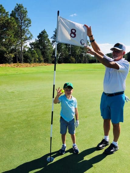 Luke Rhodes and his grandfather Ray commemorate Luke’s ace on the 8th hole of The Cradle.