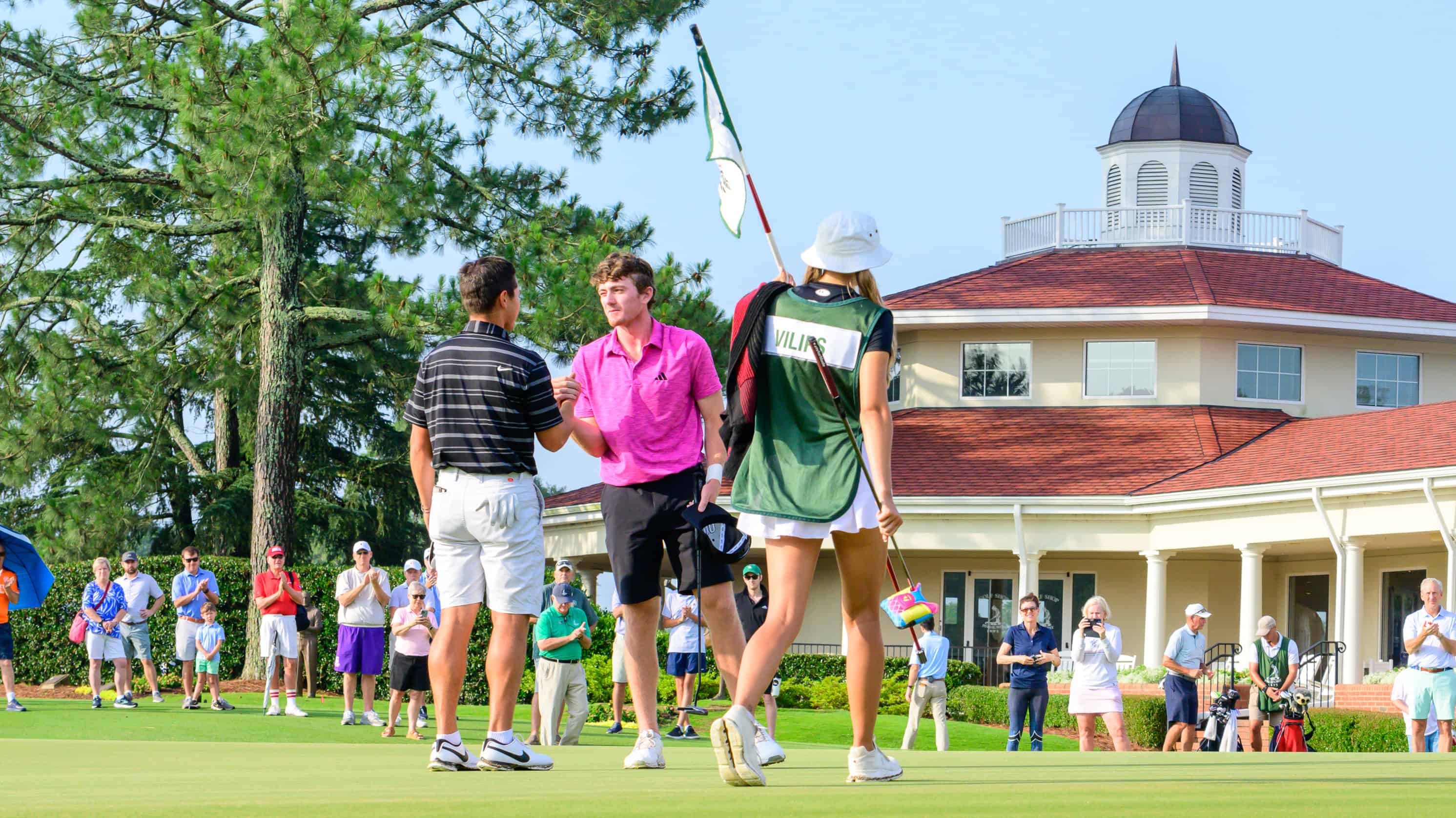 Nick Dunlap is congratulated by Karl Vilips on the 18th green of Pinehurst No. 2. (Photo by John Patota)